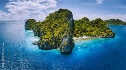 Aerial drone panorama view of tropical paradise island. Karst limestone rocky mountains surrounds by blue ocean and coral reef