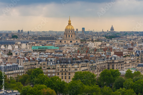 Beautiful aerial cityscape view of Paris with the golden dome of the Les Invalides complex surrounded by the typical Parisian residential buildings on a summer day. 