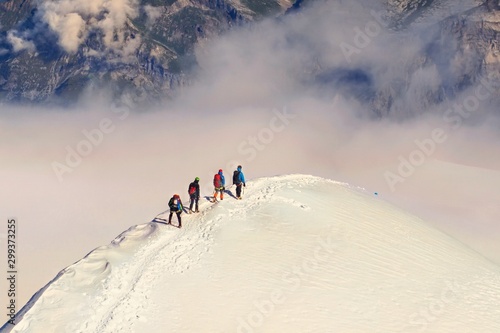 Extreme winter sports: climber at the top of a snowy peak in the Alps. Concepts: determination, success