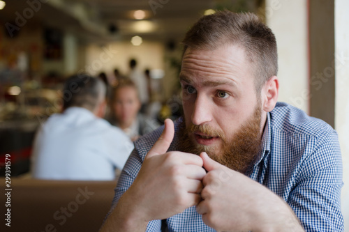 people in cafe bearded caucasian man during emotional discussion talk with gesticulation hard trouble