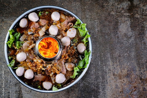 Thai style meat soup in a hotpot with vegetable on wood background