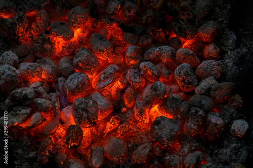 Coals of a bonfire burning at night .