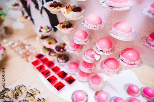 Delicious sweets on wedding candy buffet with desserts, cupcakes