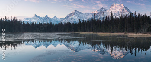 Almost nearly perfect reflection of the Rocky mountains in the Bow River. Near Canmore, Alberta Canada. Winter season is coming. Bear country. Beautiful landscape background concept.