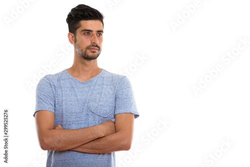 Studio shot of young Persian man thinking with arms crossed