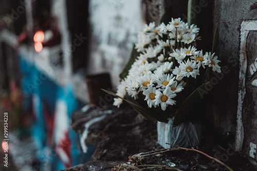 Bouquet of flowers offered or given to the dead, in one of the apartment tombstones, during a visit in the cemetery during All Souls Day. Selective focus. Copy space.