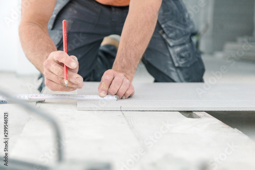  Fliesenleger bei der Arbeit , handwerker schneidet fliesen mit schneidetisch werkzeug