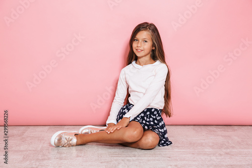 Girl child posing isolated over pink wall background