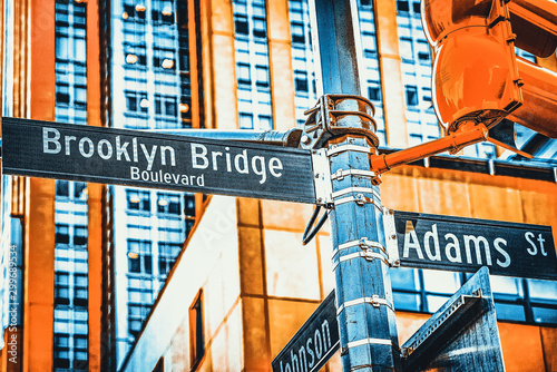 Street sign (nameplate) of Brooklyn Bridge and Adams Street and urban cityscape of New York. USA.