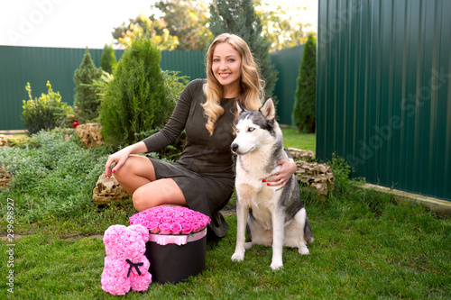 Girl celebrates birthday with a dog. Bouquet of 51 pink roses and mika of roses.