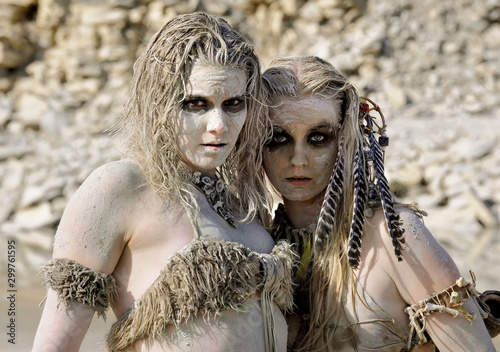 Two girls are dressed as prehistoric warriors. They are covered with mud, filth and dirt and are seen in a stone quarry.