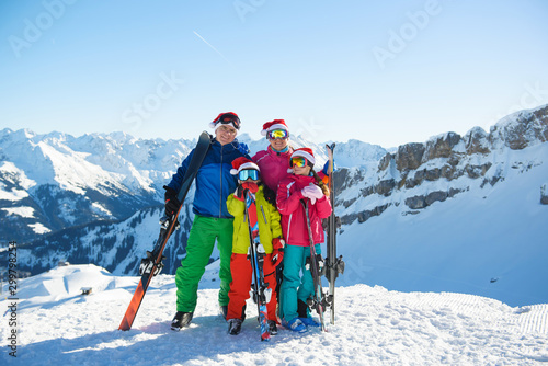 Happy family in Santa hats enjoying Christmas holidays in the mountains . Ski, Sun,Snow and fun.