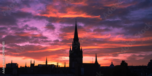 Silhouette of cityscape of Aberdeen in Scotland. Church tower and buildings in the city center. Beautiful colorful sunset in Aberdeen. Pink and blue sky. Low light photography.