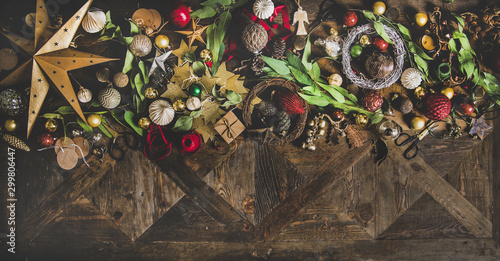 Christmas, New Year holiday layout background, texture or wallpaper. Flat-lay of decorative objects, fur tree toys, garlands, ropes, candles, glass balls, wreaths over wooden background, copy space