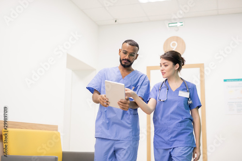 One of two clinicians making presentation or explaining something to colleague