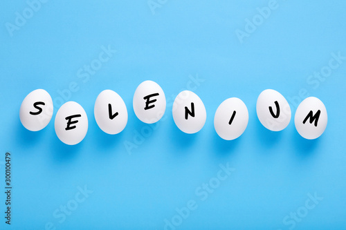 Fresh white farm eggs lined up in a row with the word selenium written on them