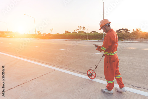 A worker is walking with the measuring wheel, measure the road