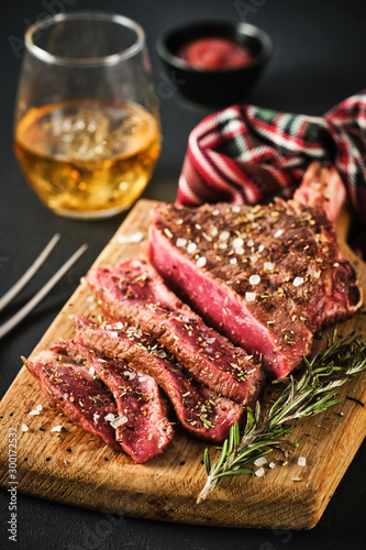 Entrecote. Steak on the bone. Rib eye. Tomahawk steak on the on a cutting board with rosemary. Roasting - Rare