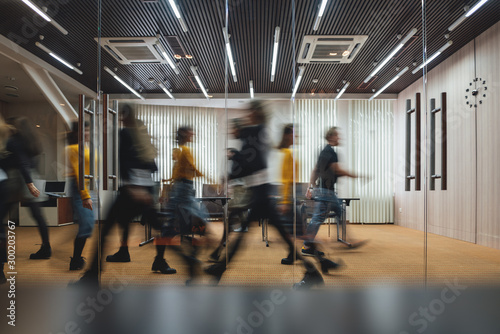 Group of business people walking at modern open space. Team of business employees at coworking center. Motion blur. Concept work in process