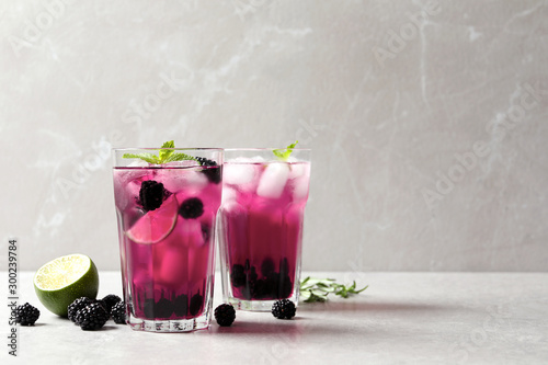 Delicious refreshing blackberry lemonade on light table. Space for text
