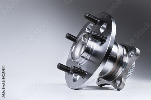 New Wheel hub assembly with bearing. This is part of the car suspension on a gray background with a gradient. The concept of new car parts