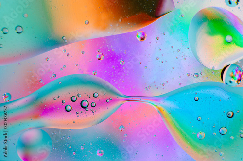 Neon abstract macro background of moving oil drops