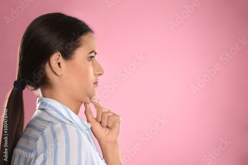 Young woman with double chin on pink background. Space for text