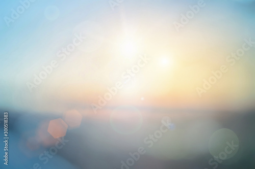 Natural background blurring warm colors and bright sun light. Bokeh or Christmas background Green Energy at sky sunny color orange light patterns plain abstract flare evening clouds blur.