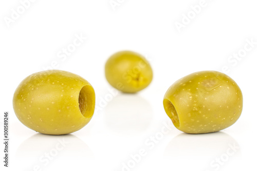 Group of three whole pitted green olive two in focus isolated on white background