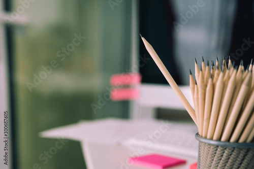 Business concept - lot of pencils and the pencil is higher than the other one on blur background. It's symbol of leadership, teamwork, united and communication.