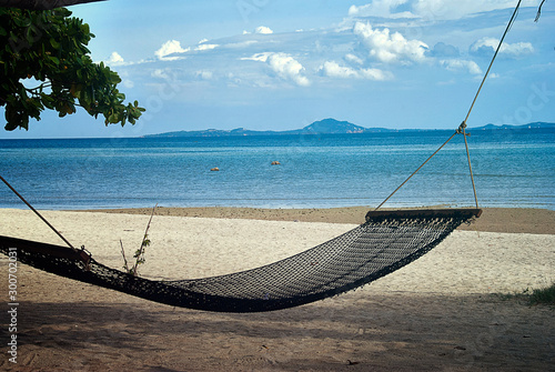 Hammock hanging between two trees on a beautiful Thai island. A relaxing holiday landscape