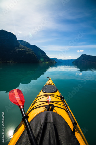 gelbes Kajak mit paddel auf einem Fjord, Berge im Hintergrund