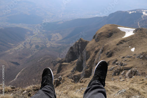 First person perspective shot from a hiker sitting at the edge of a cliff