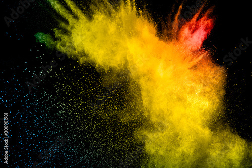 Red yellow powder explosion on black background.Red yellow color dust splash clouds.