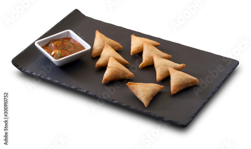 empanadillas de carne y verduras con salsa sobre pizarra. meat and vegetable dumplings with sauce on slate.