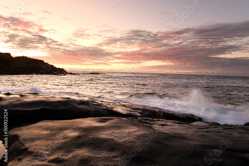 Dawn on the shore of the Atlantic Ocean. Waves crash against the rocky shore and the island in the background Atlantic Ocean. USA. Maine. Nubble york 