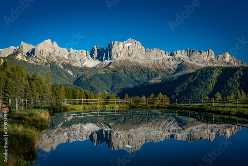 Reflections of the Rosengarten mountains in the water of the Wuhnleger pond near Tiers