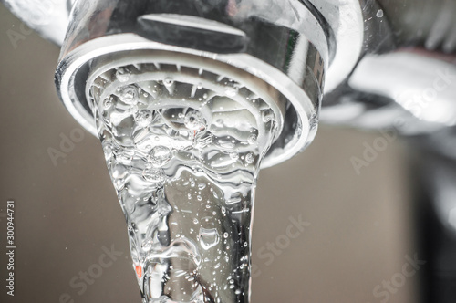 Frozen water stream from a tap Close-up. Aerator operation for saving water consumption.