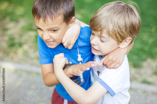 Two boys fighting outdoors. Siblings rivalry.