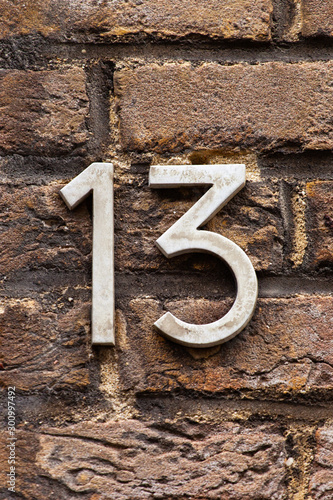 brass number 13 on brick wall