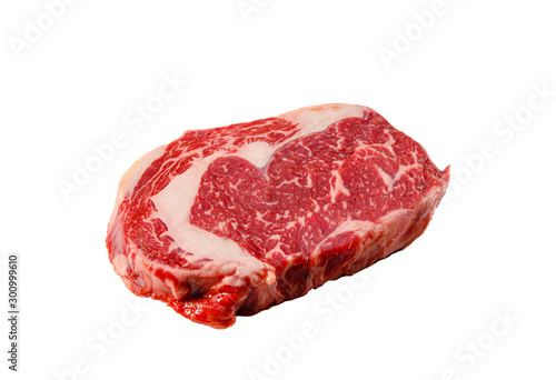 A rib eye steak of marbled grain-fed beef lies on a white background. Isolated.