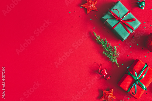 Christmas composition. Gift box, christmas decorations on red background. Flat lay, top view, copy space