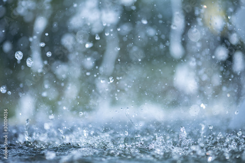 blue color tone of close up rain water drop falling to the floor in rainy season 