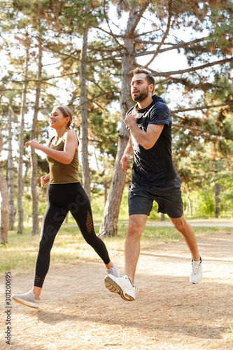Photo of young attractive couple running while working out
