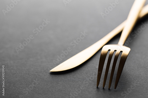 Gold cutlery set on black background