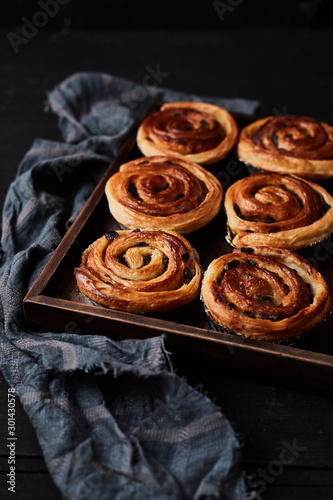 Fresh danish pastry with raisins on wood background.Tasty sweet bakery.