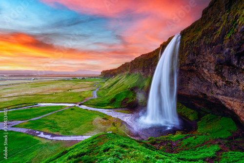 Sunrise on Seljalandfoss waterfall on Seljalandsa river, Iceland, Europe. Amazing view from inside. Landscape photography