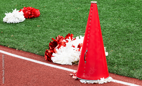 Red and white cheerleading megaphone and pop poms