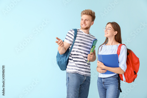 Portrait of female and male students on color background