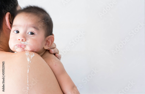 Close up of asian father is holding his baby to belching after breast feeding time, concept of parent care to the child and over feeding in baby.